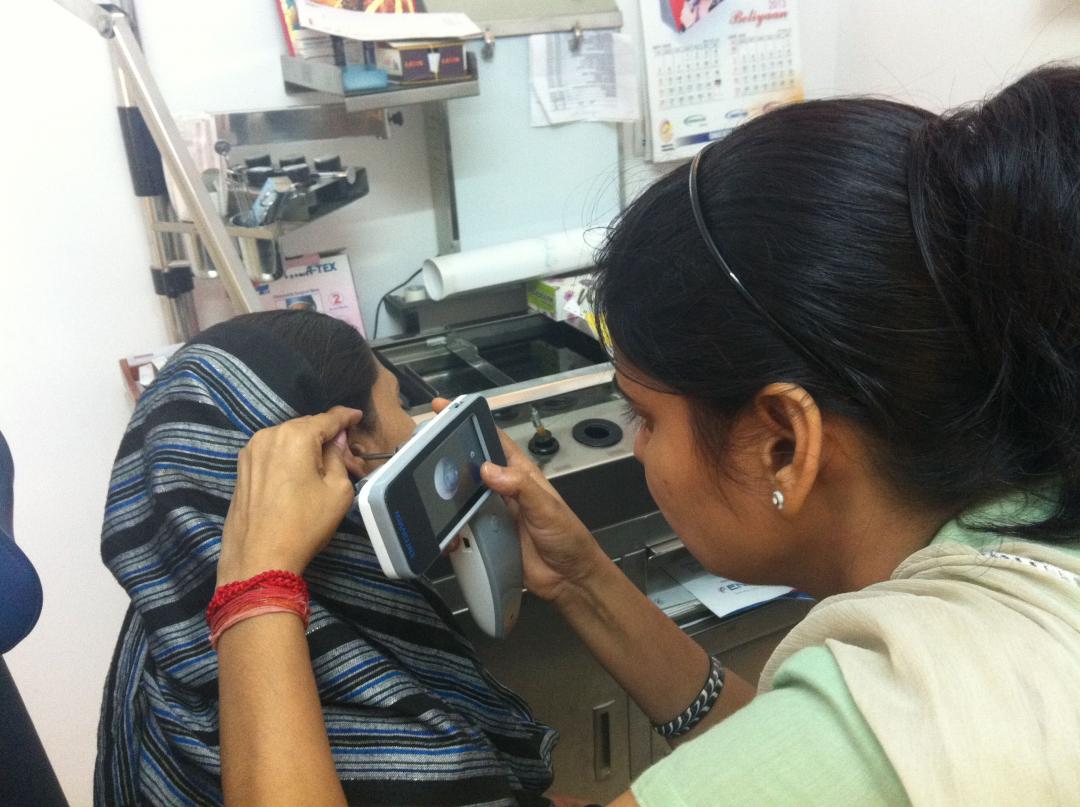 A rural health worker conducts an ear screening using the ClickMedix- Medtronic application