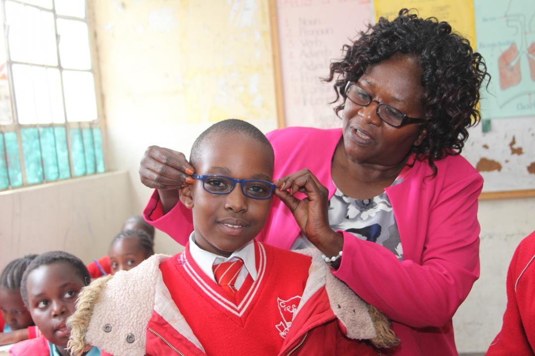Woman putting glasses on a boy