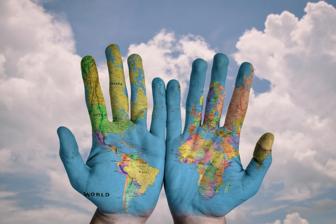 A pair of hands with the world map