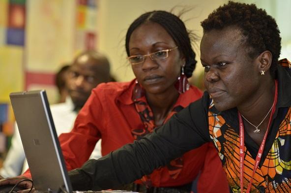 two African women working on a laptop together