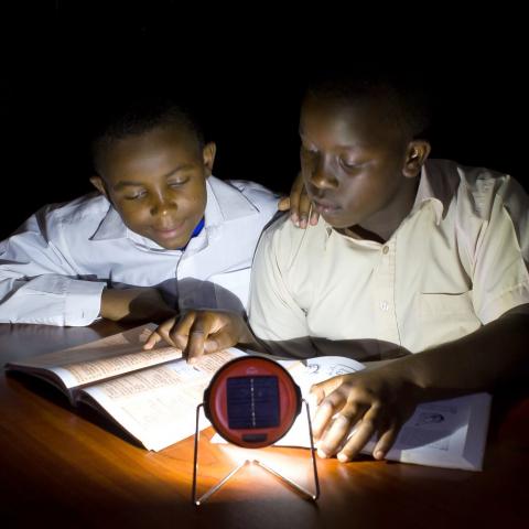 Two boys reading in with solar light