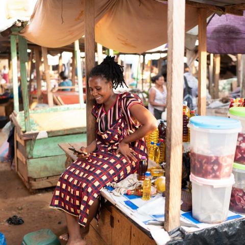 an African woman checking her phone in a market