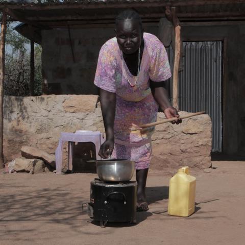 African woman using cooking stove