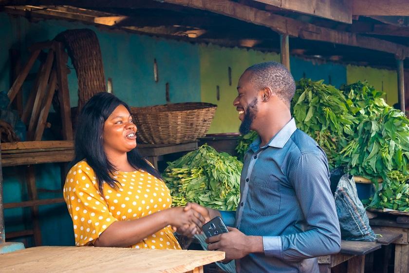 African businessman shaking hand with marketwoman
